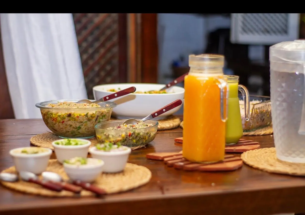 Mesa servida con ensaladas, jugos de colores y pequeños bowls