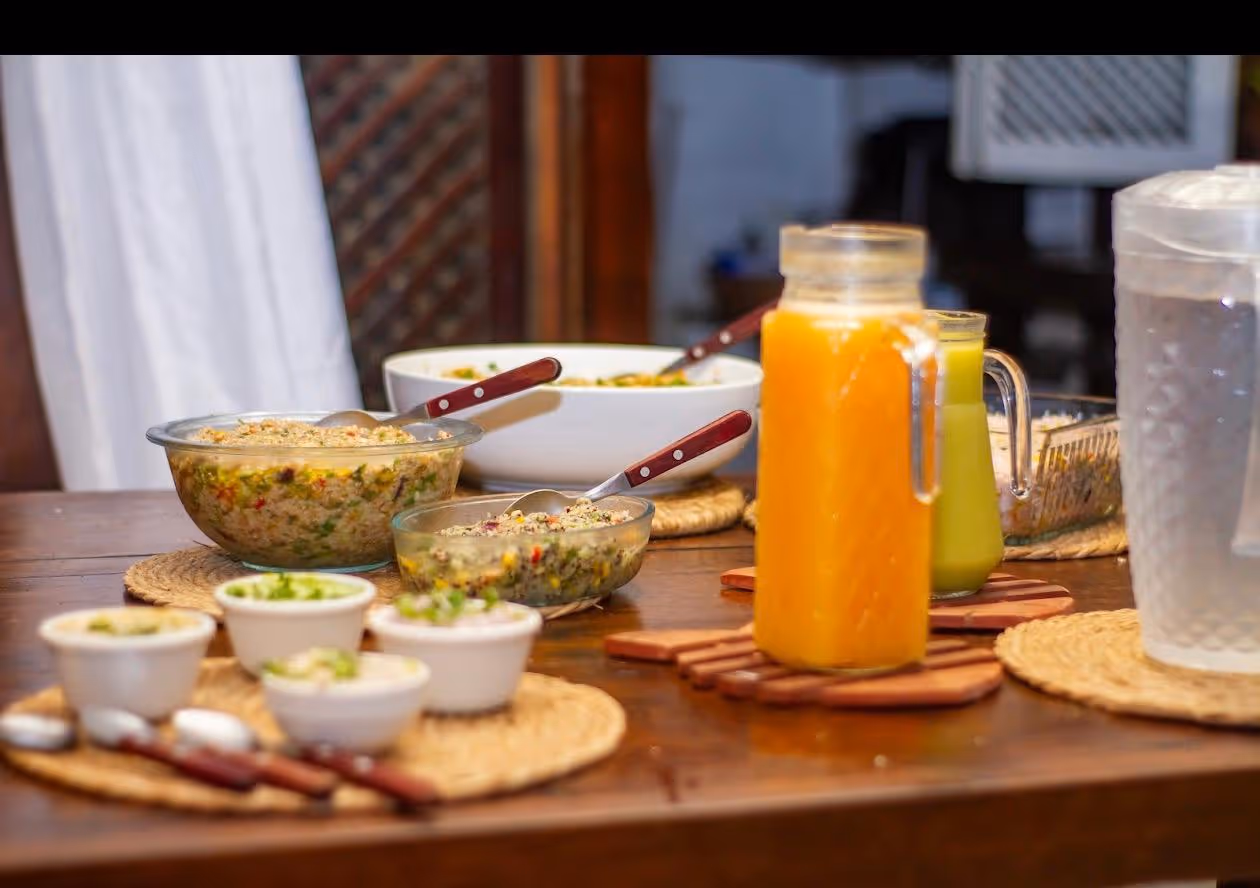 Mesa servida con ensaladas, jugos de colores y pequeños bowls