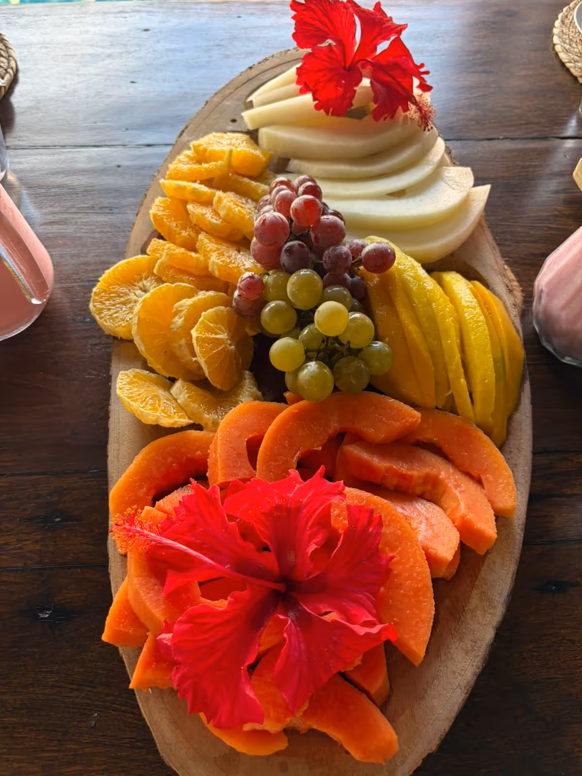 Tabla de frutas tropicales decorada con flores de hibisco