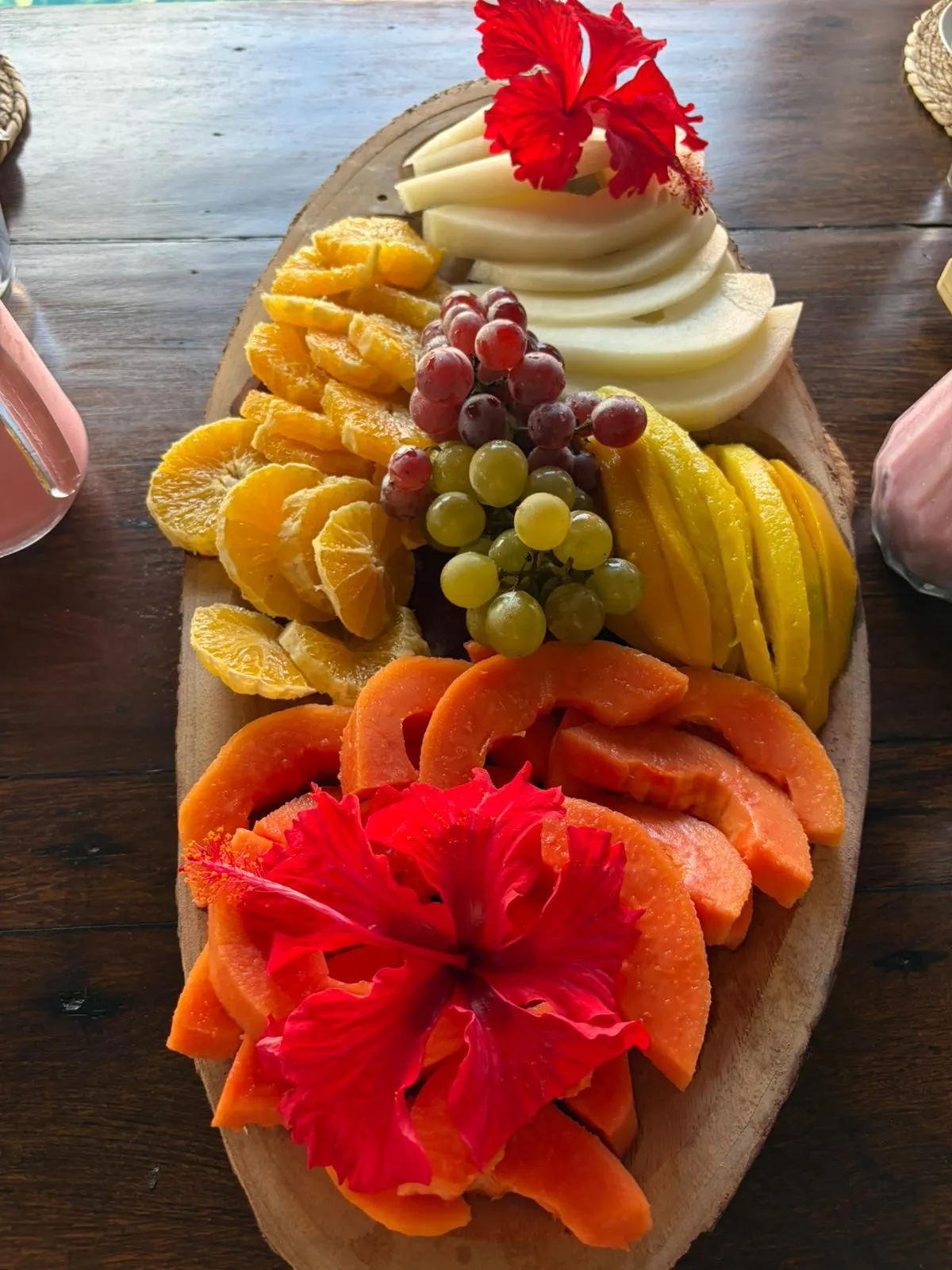 Tabla de frutas tropicales decorada con flores de hibisco