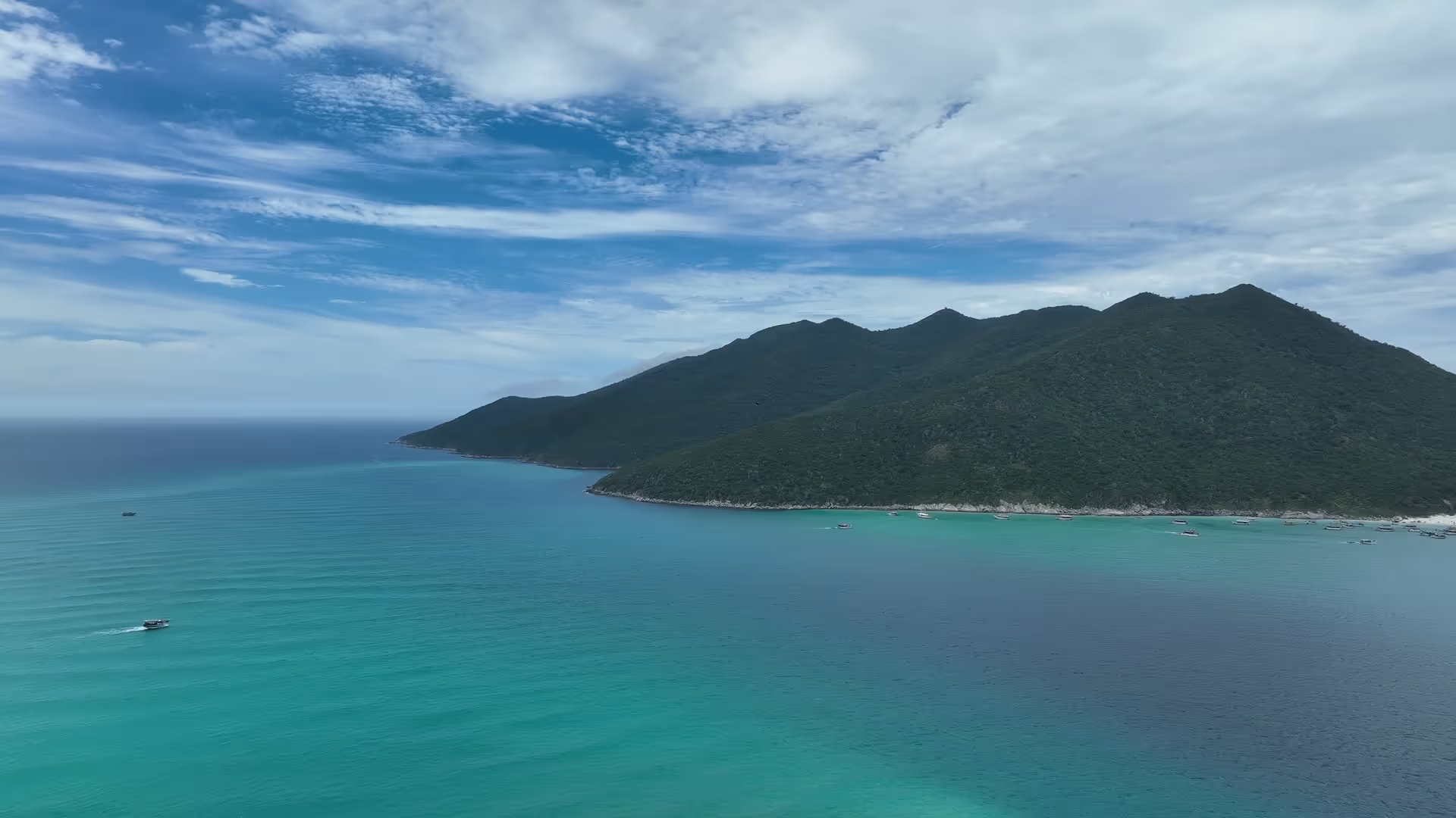 Vista aérea de Arraial do Cabo, mar turquesa cristalino con una persona nadando junto a una tortuga marina