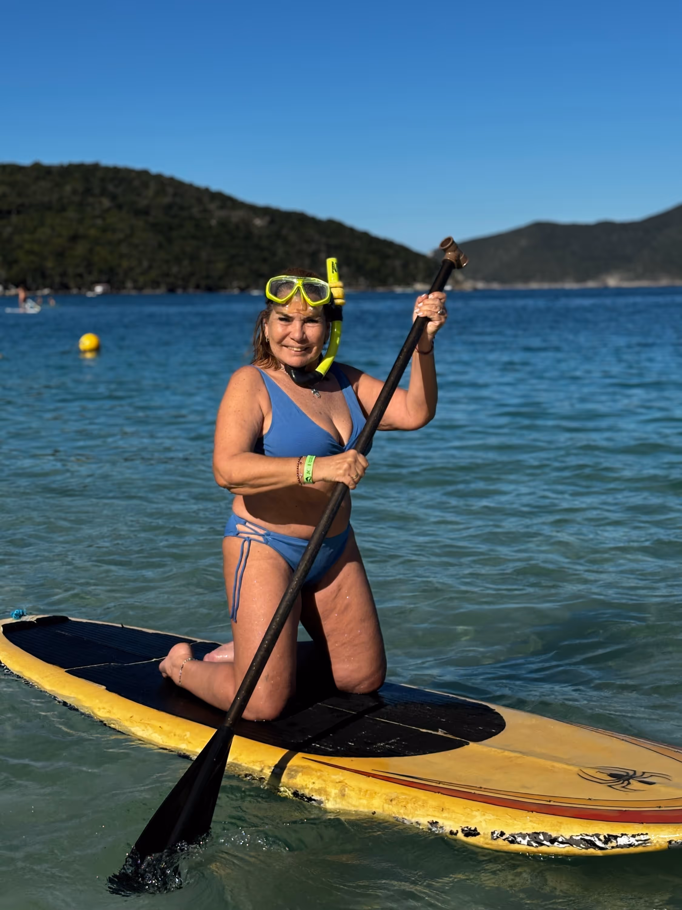 Persona haciendo stand up paddle en el mar turquesa de Arraial do Cabo