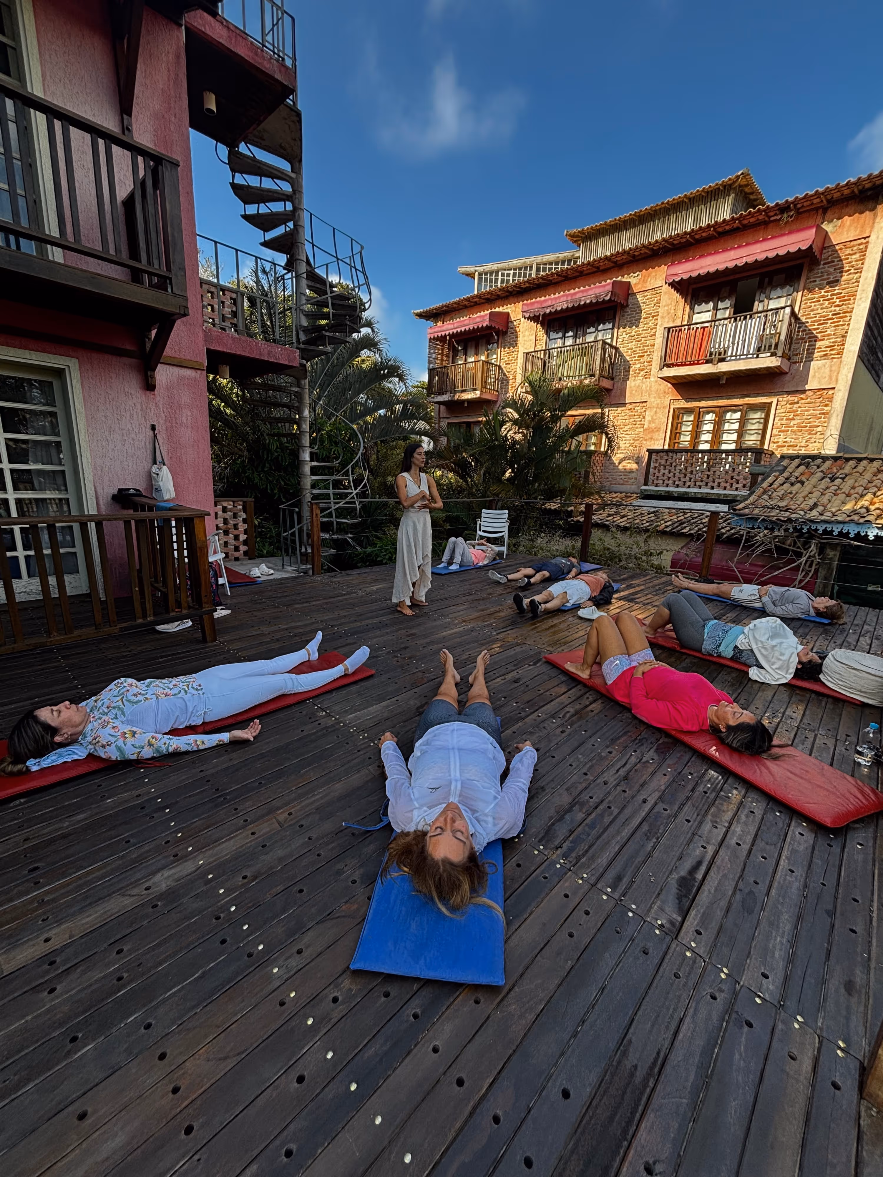 Grupo de mujeres practicando yoga en la playa al atardecer
